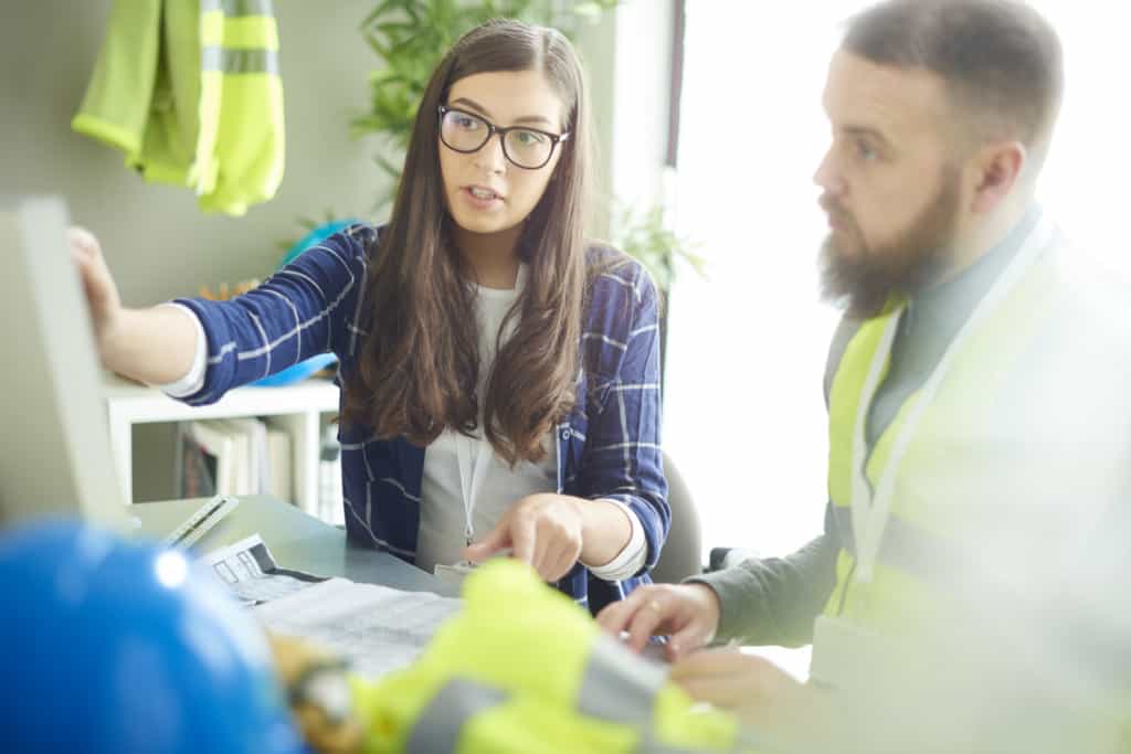 Male and Female construction workers looking over plans